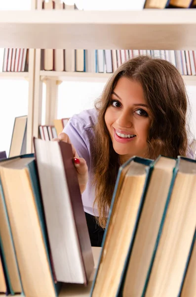 Ung kvinnlig student förbereder sig för tentamen på biblioteket — Stockfoto