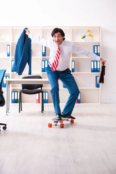 Ung stilig affärsman med longboard på kontoret — Stockfoto