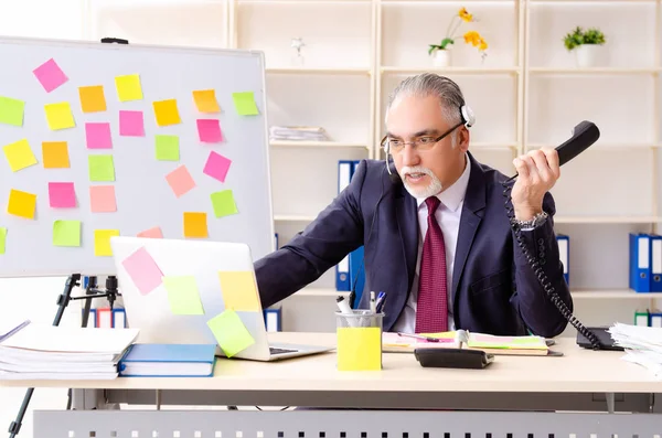 Leeftijd man werknemer in tegenstrijdige prioriteiten concept — Stockfoto