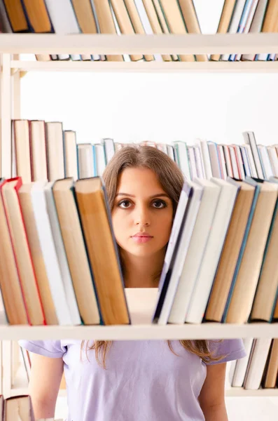 Junge Studentin bereitet sich in Bibliothek auf Prüfungen vor — Stockfoto