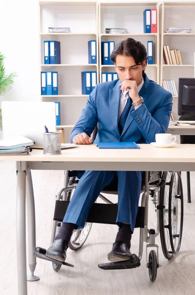 Male employee in wheelchair working at the office