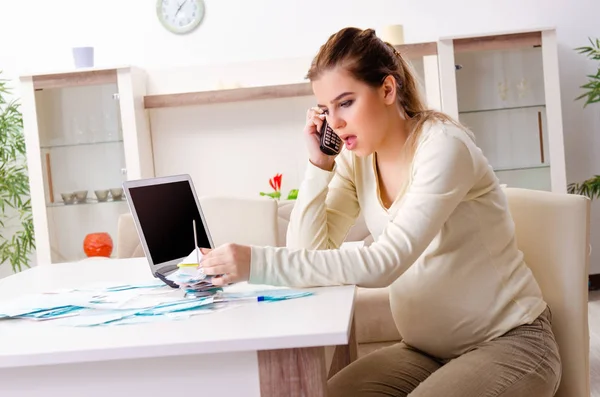 Jonge zwangere vrouw in budget planning concept — Stockfoto