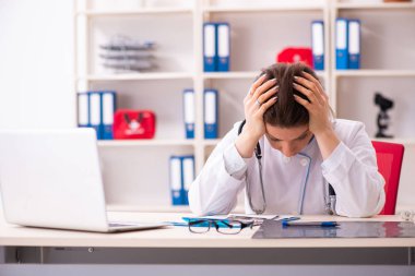 Klinikte çalışan yaşlı bir kadın doktor.