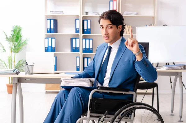 Male employee in wheelchair working at the office