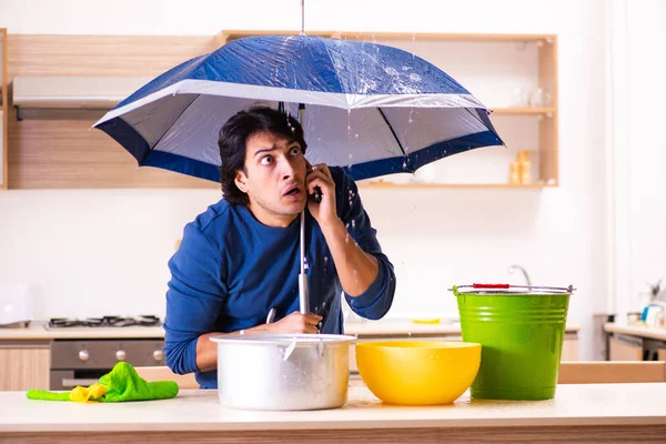Young man in water leakage from the neighbors concept — Stock Photo, Image
