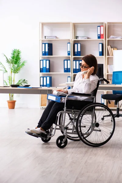 Employée en fauteuil roulant au bureau — Photo