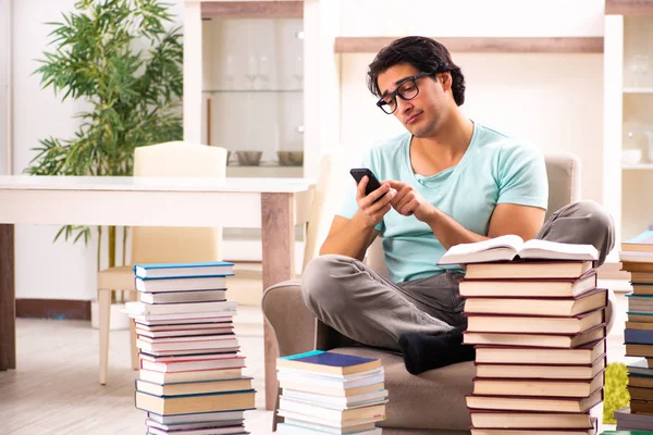 Estudiante masculino con muchos libros en casa — Foto de Stock