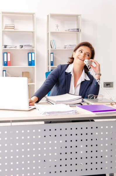 Middle-aged female employee sitting at the office — Stock Photo, Image