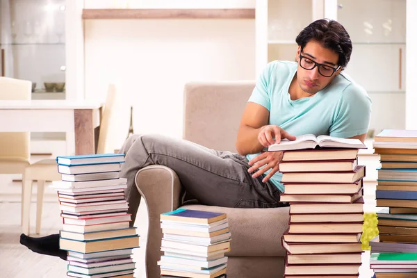 Studente maschio con molti libri a casa — Foto Stock