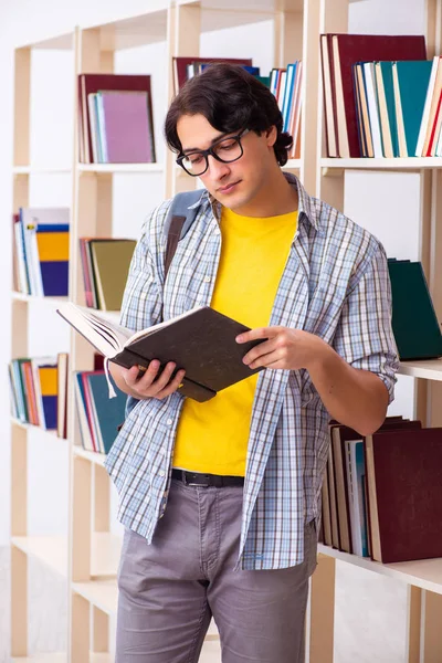 Estudante do sexo masculino se preparando para exames na biblioteca — Fotografia de Stock