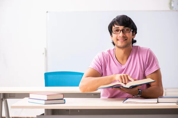Ung manlig student som sitter i klassen — Stockfoto