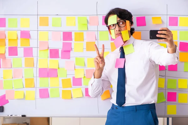 Young employee in conflicting priorities concept — Stock Photo, Image