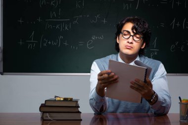 Kara tahta önünde genç matematik öğretmeni