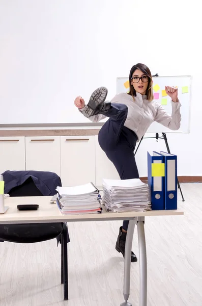 Giovane impiegata che fa esercizi sul posto di lavoro — Foto Stock