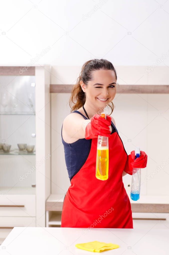 Young beautiful woman cleaning apartment