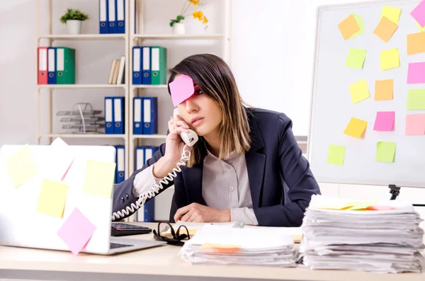 Joven empleada en el concepto de prioridades conflictivas — Foto de Stock