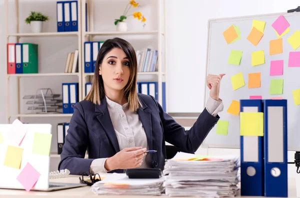 Joven empleada en el concepto de prioridades conflictivas — Foto de Stock