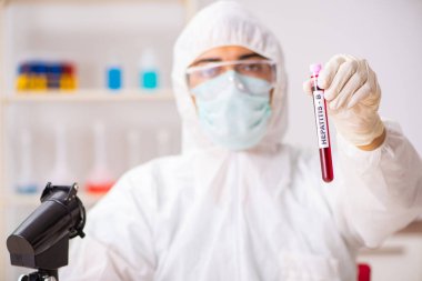 Genç yakışıklı laboratuvar asistanı hastanede kan örnekleri test ediyor.