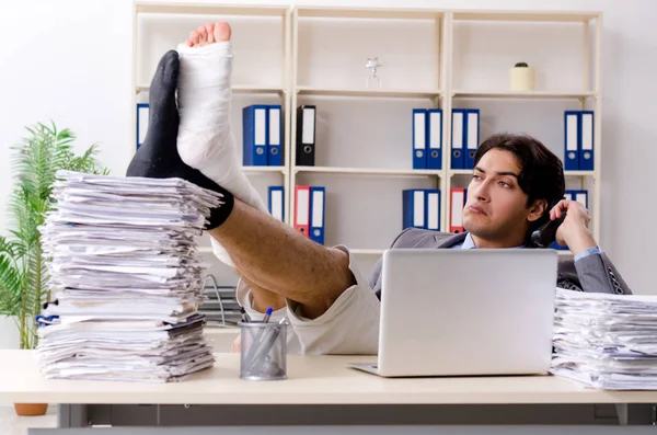 Leg injured employee working in the office — Stock Photo, Image