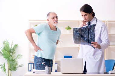 Yaşlı adam genç erkek doktoru ziyaret ediyor.