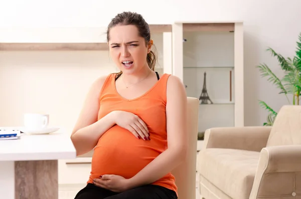 Giovane donna incinta che lavora a casa — Foto Stock