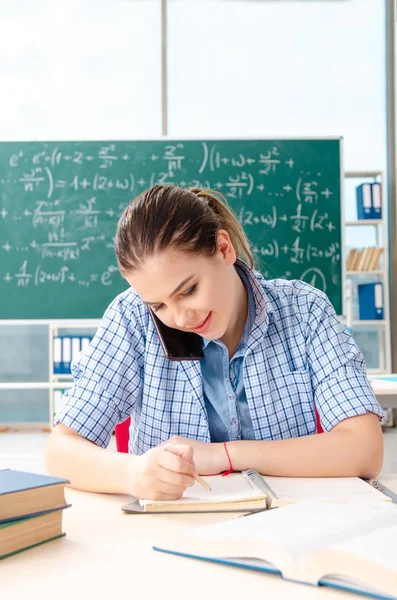 Young female student taking the exam in classroom — Stock Photo, Image