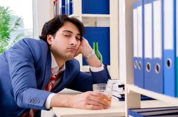 Jovem empresário empregado bebendo no escritório — Fotografia de Stock