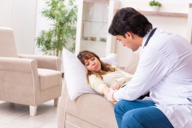 Genç, yakışıklı doktor, kadın hastayı evinde ziyaret ediyor.