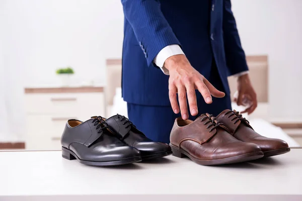 Young handsome businessman choosing shoes at home — Stock Photo, Image