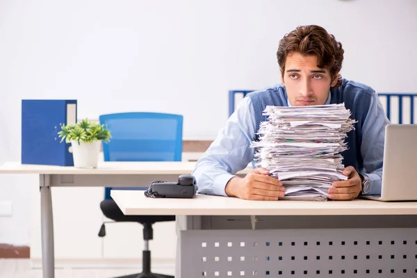 Joven empleado guapo infeliz con el trabajo excesivo — Foto de Stock