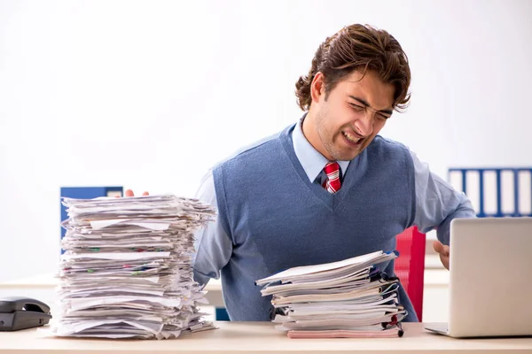 Young handsome employee unhappy with excessive work — Stock Photo, Image