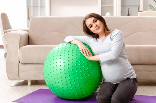 Mladá těhotná žena dělá sportovní cvičení doma — Stock fotografie