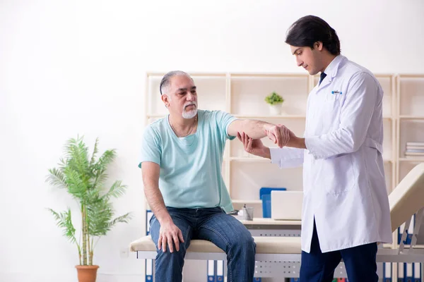 Alt mann besuch jung männlich doktor — Stockfoto