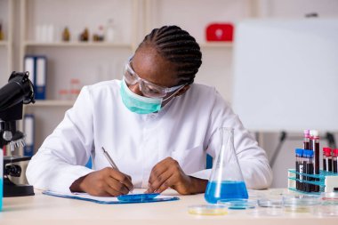 Laboratuarda çalışan genç siyah kimyager