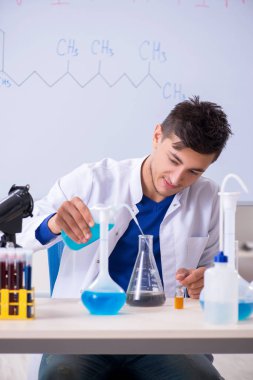 Laboratuarda oturan genç kimyager