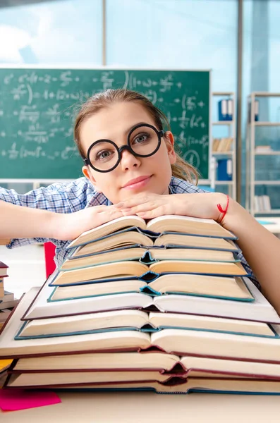 Female student with many books sitting in the classroom — Stock Photo, Image