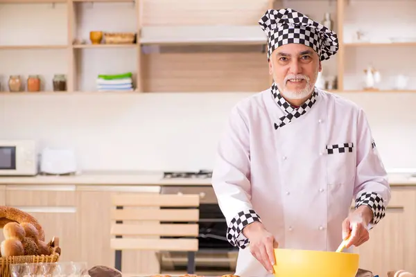 Régi férfi baker dolgozik a konyhában — Stock Fotó