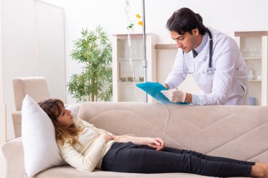 Genç, yakışıklı doktor, kadın hastayı evinde ziyaret ediyor.
