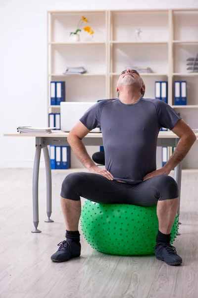 Branco barbudo velho empregado fazendo exercícios no escritório — Fotografia de Stock