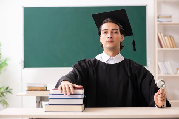 Estudante graduado na frente do quadro verde — Fotografia de Stock