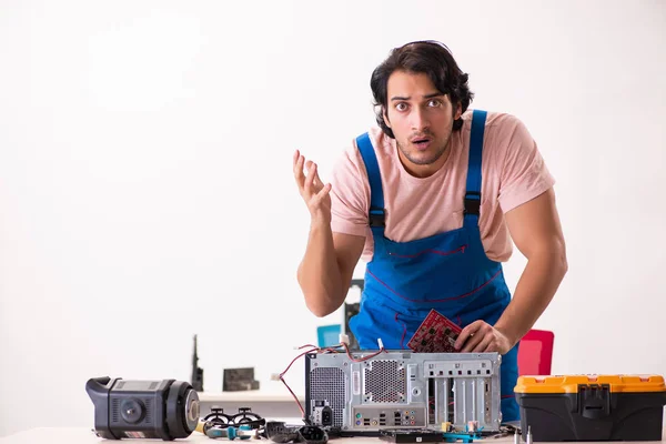 Jovem empreiteiro do sexo masculino reparando computador — Fotografia de Stock