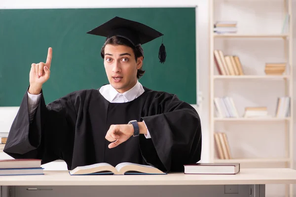 Graduate student in front of green board — Stock Photo, Image