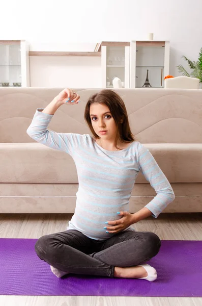 Genç hamile kadın spor egzersizleri evde yapıyor — Stok fotoğraf