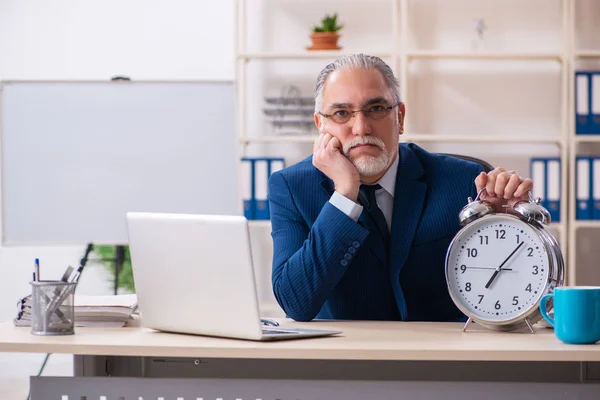 Verouderde mannelijke werknemer werkzaam in het kantoor — Stockfoto