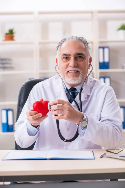Лікар-кардіолог у віці з моделлю серця — стокове фото
