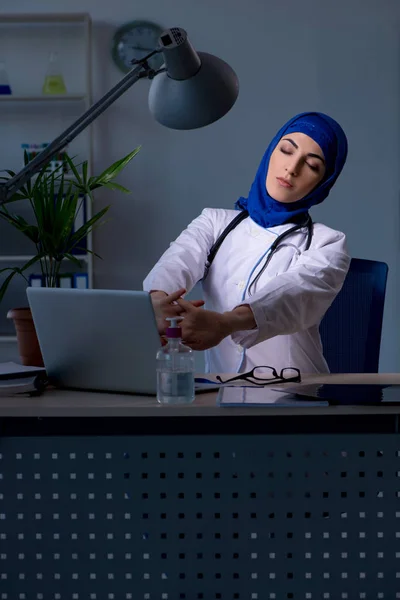 夜の診療所で働くアラブ女性医師 — ストック写真