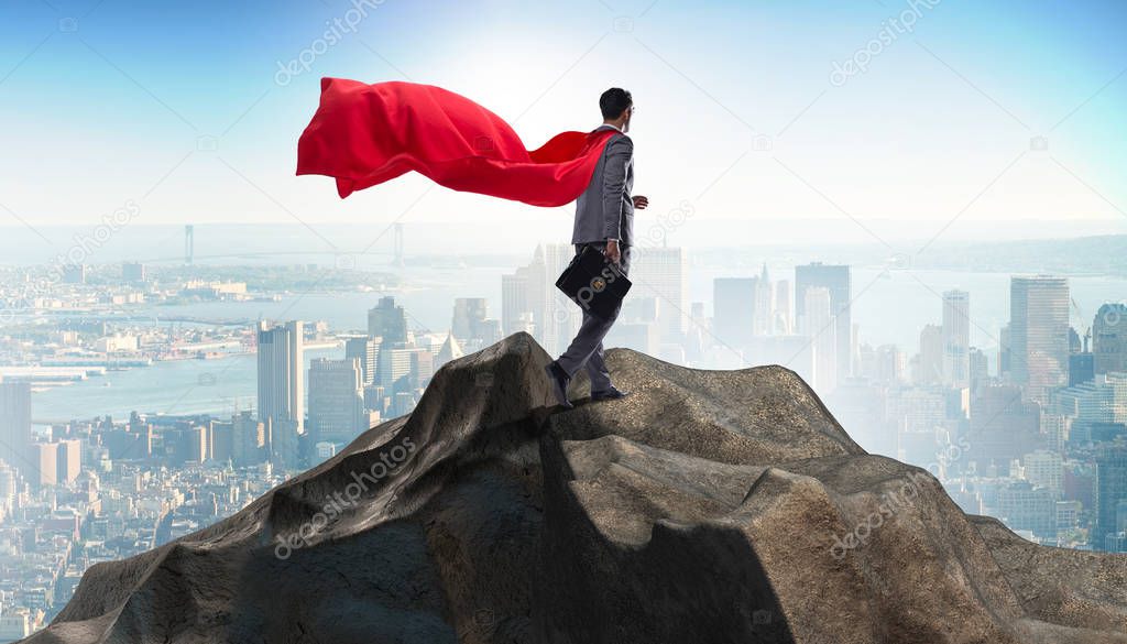 Superhero businessman on top of mountain