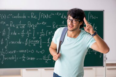 Kara tahta önünde genç erkek öğrenci matematikçi