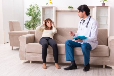 Genç, yakışıklı doktor, kadın hastayı evinde ziyaret ediyor.