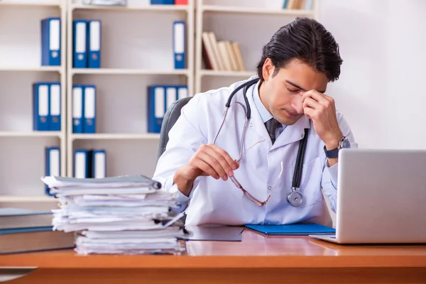 Jonge knappe dokter werkt in de kliniek — Stockfoto